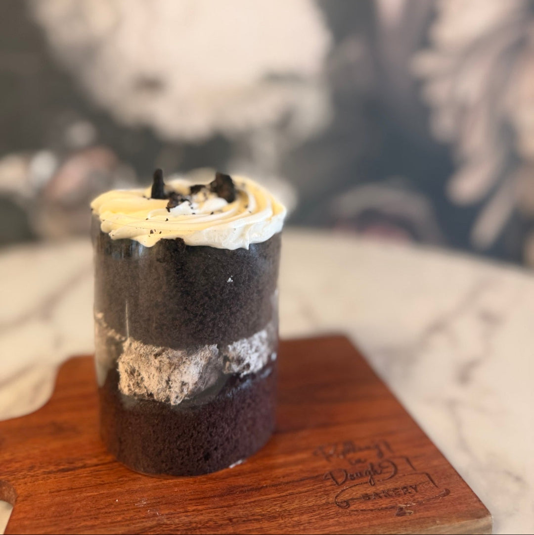 Layered dessert on a wooden board with a blurred background, chocolate cake oreo mousse