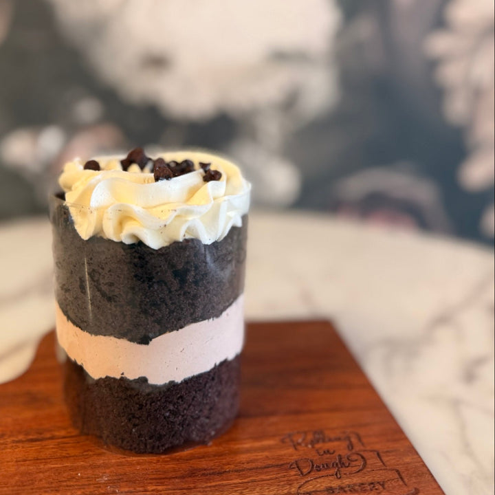 Layered dessert on a wooden board with a blurred background, chocolate with milk chocolate mousse