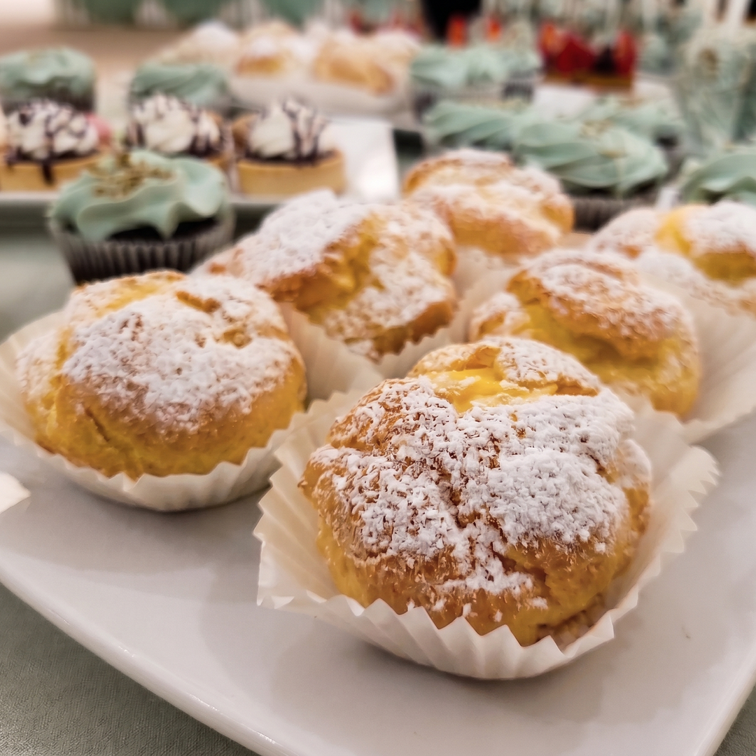 Mini cream puffs made with delicate choux pastry filled with smooth vanilla cream and dusted with powdered sugar.