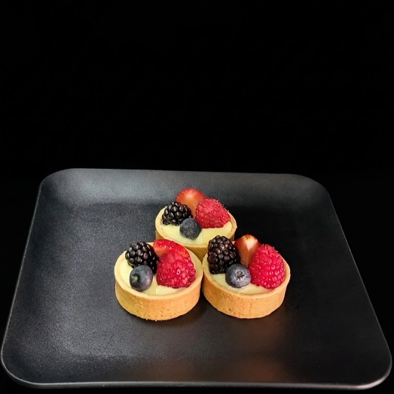 Mini 2-inch fresh fruit tart with buttery pastry shell, silky vanilla pastry cream, and assorted seasonal berries, handcrafted fresh by a luxury Las Vegas bakery.